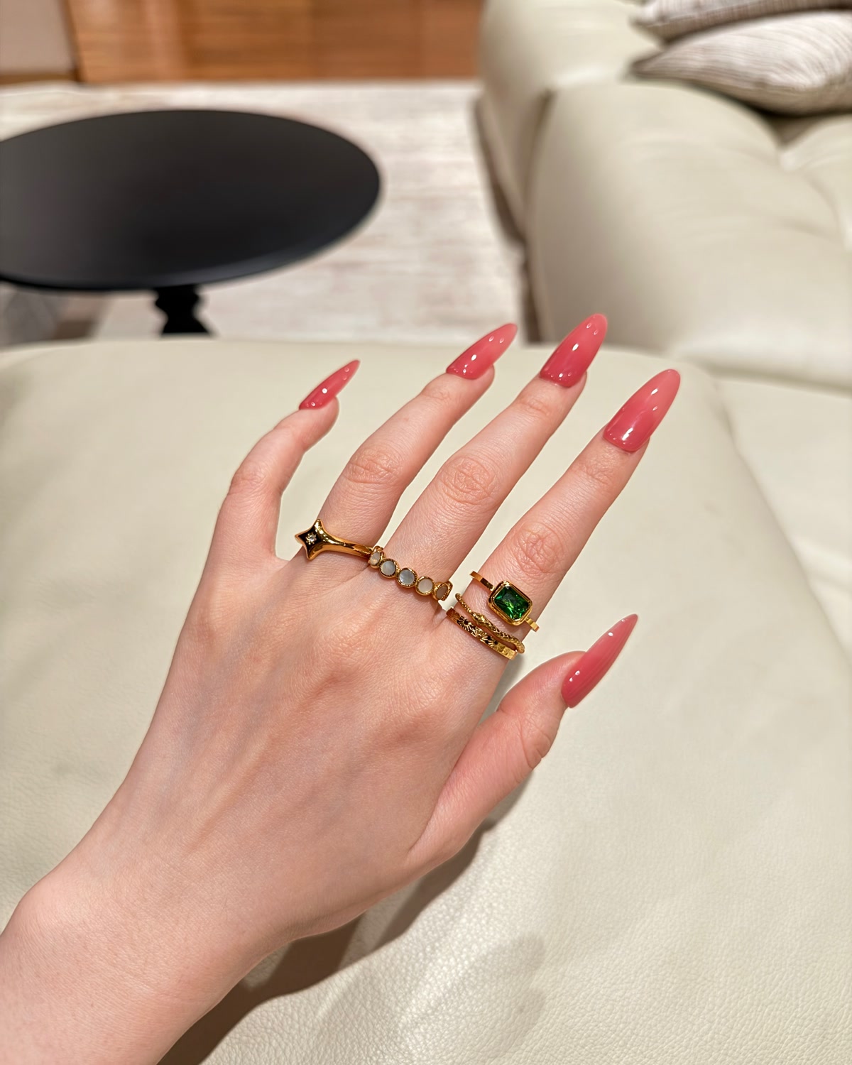 A real wearer mixing gold rings around a green stone ring